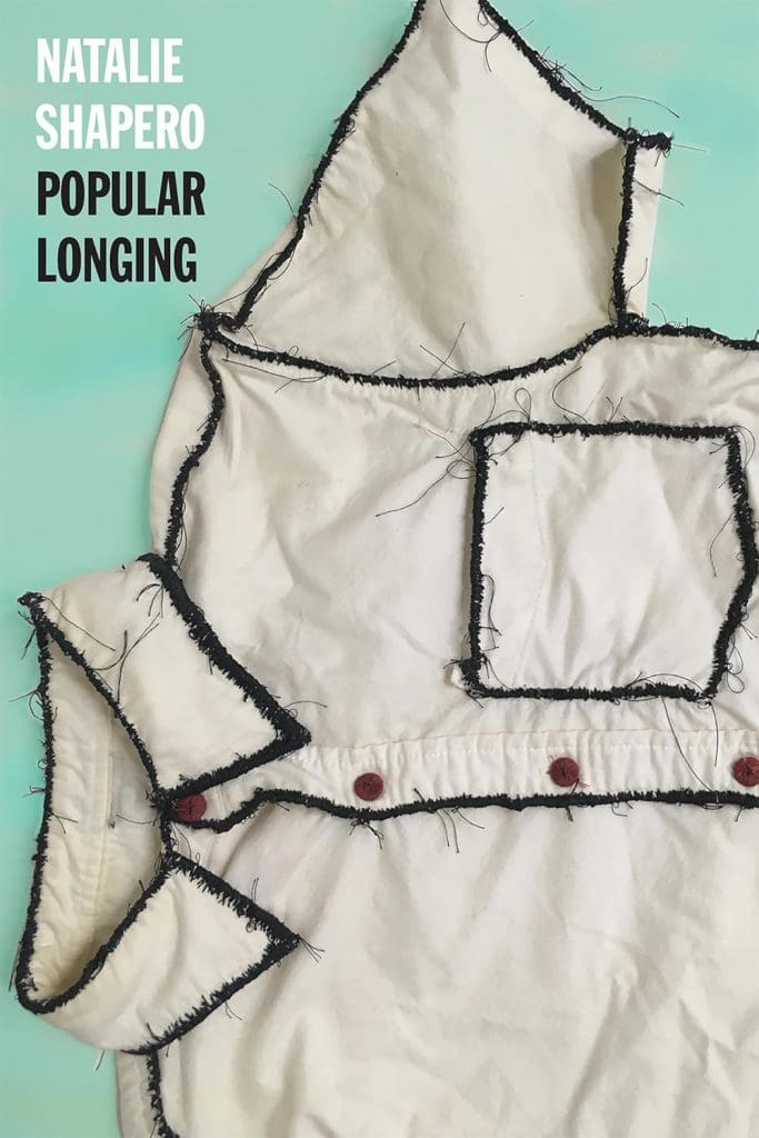 POPULAR LONGING by Natalie Shapero. Cover depicts a white button-up short sleeve shirt, home-made looking, with extremely rough black threading along the seams. 