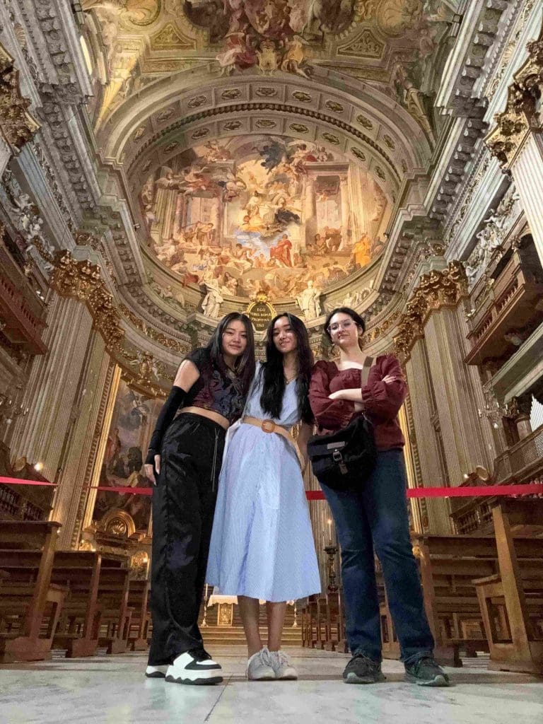 three students standing beneath the striking trompe l'oeil painted ceiling of the Chiesa di Sant'Ignazio di Loyola